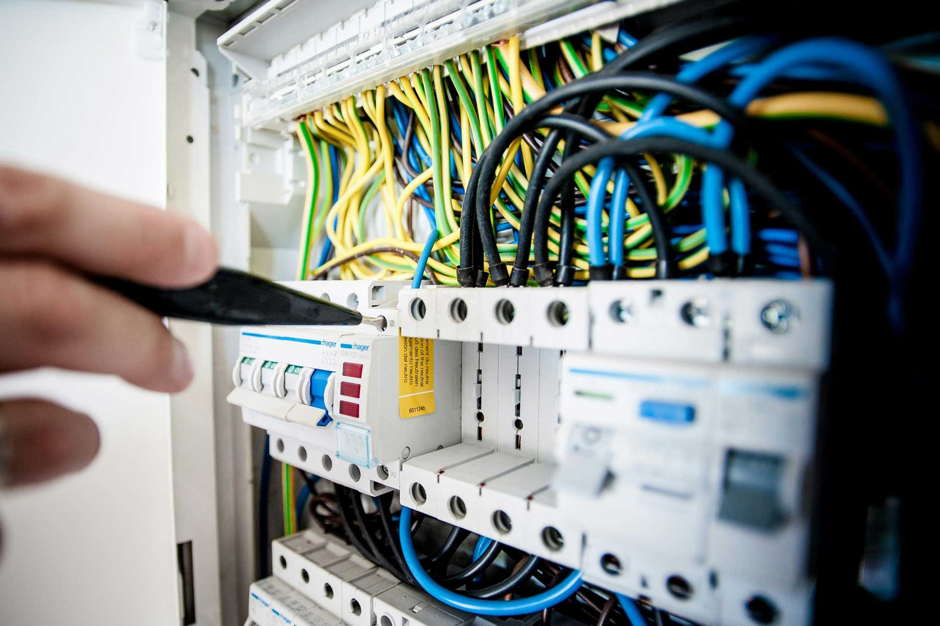 Electrician testing electrical wiring in a commercial electrical panel